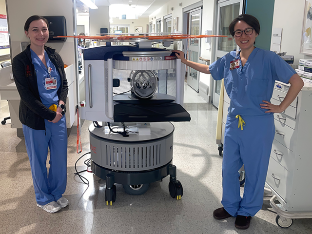 Physician assistant Kaitlyn Twomey, left, joins Dr. Judy Ch’ang, medical director of the Neurosciences Intensive Care Unit on 2South, in welcoming the new portable MRI scanner.