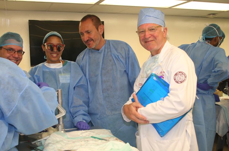 Dr. Bernardo (center) and Dr. Stieg (right) oversee students at a skull base station