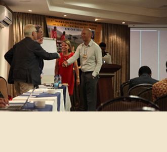 Dr. Philip Stieg (left) and Dr. Roger Härtl  greet Karen March from the USA and Dr. Anthony Figaji from South Africa.