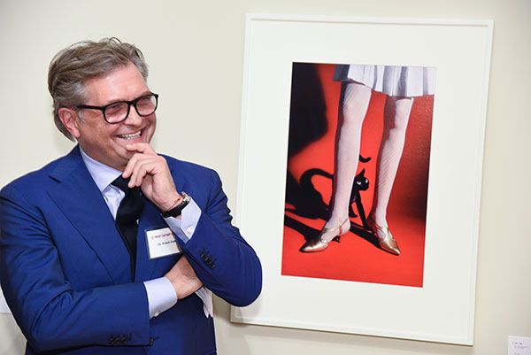 Dr. Roger Härtl in front of a whimsical Elliott Erwitt photo