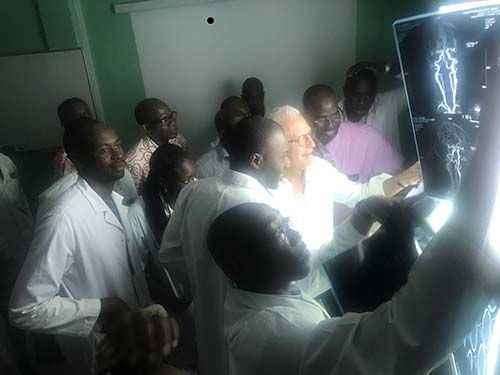 Dr. Stieg, with Dr. Cisse at his left, reviews imaging from a patient who needs surgery